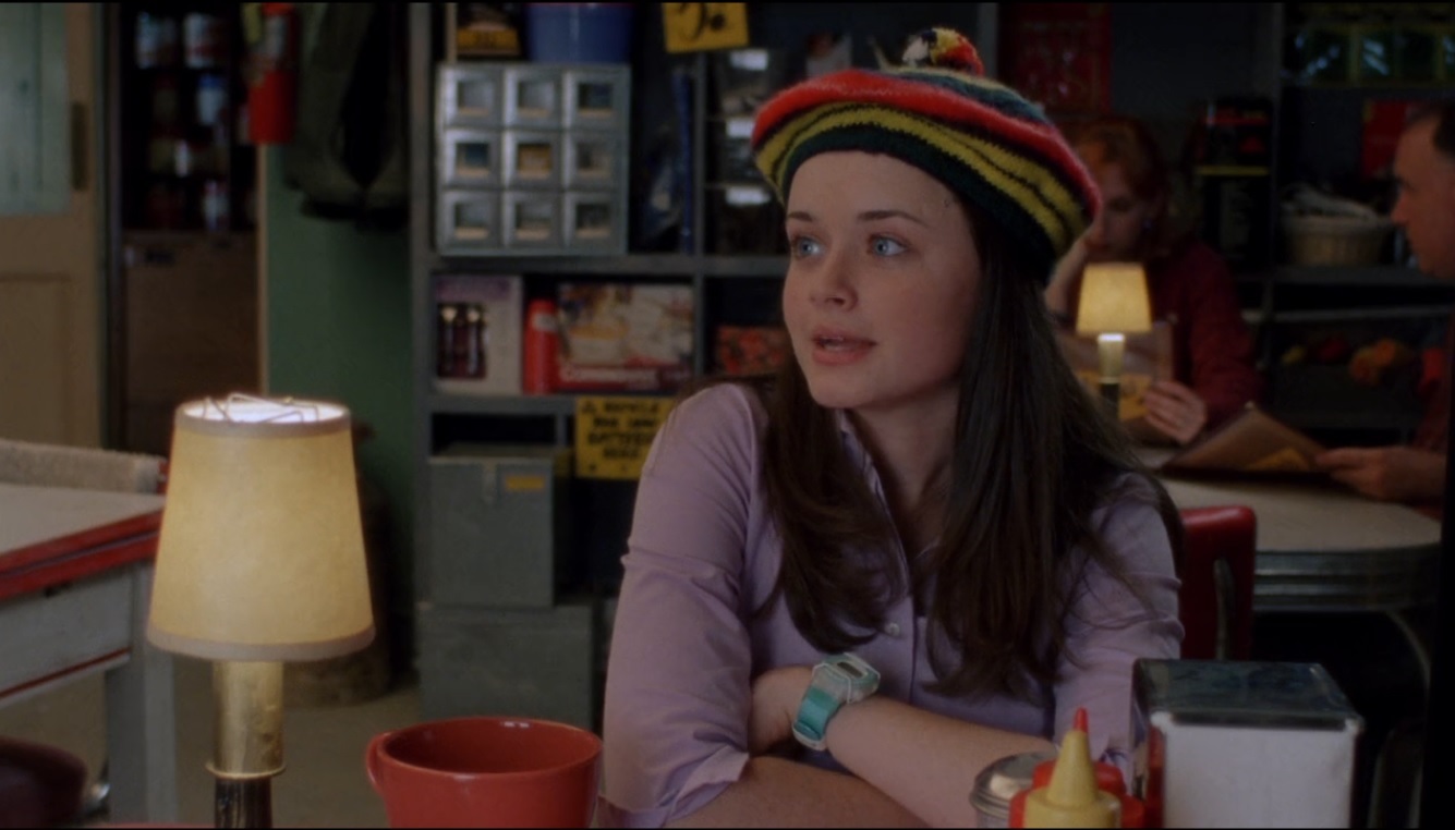 Rory leaning over a table in Luke's diner. Prominent on her wrist is a sky blue baby-G G-File watch.